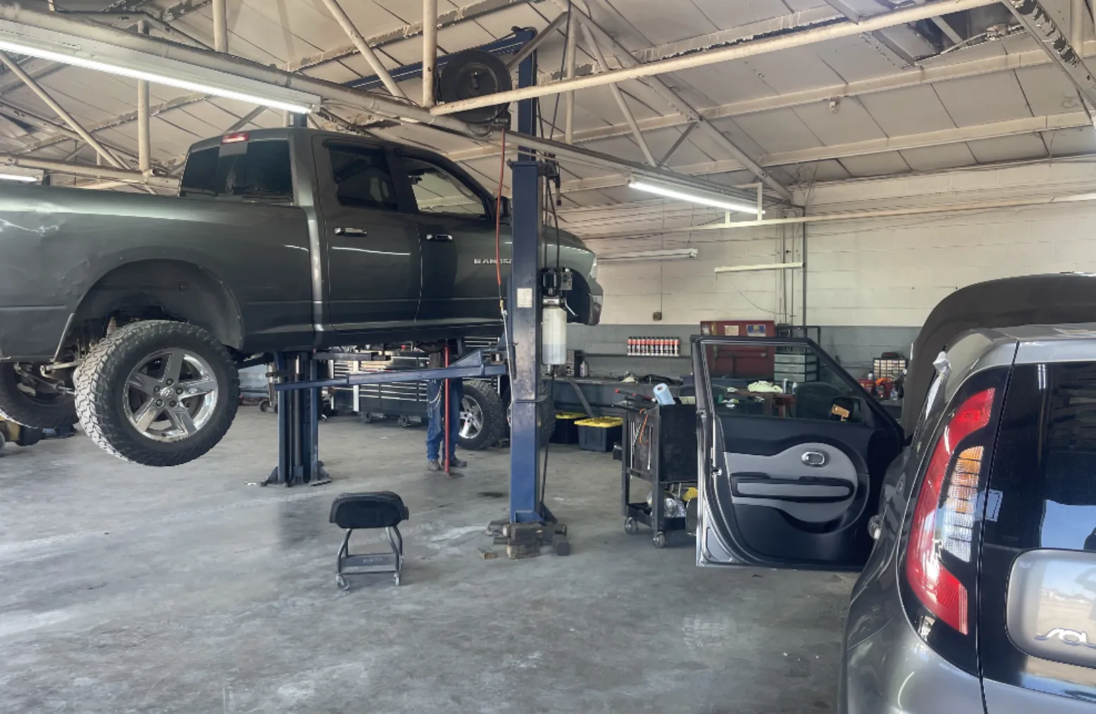 Inside the Quality Automotive Repair shop: a pickup truck raised on a lift in a service bay